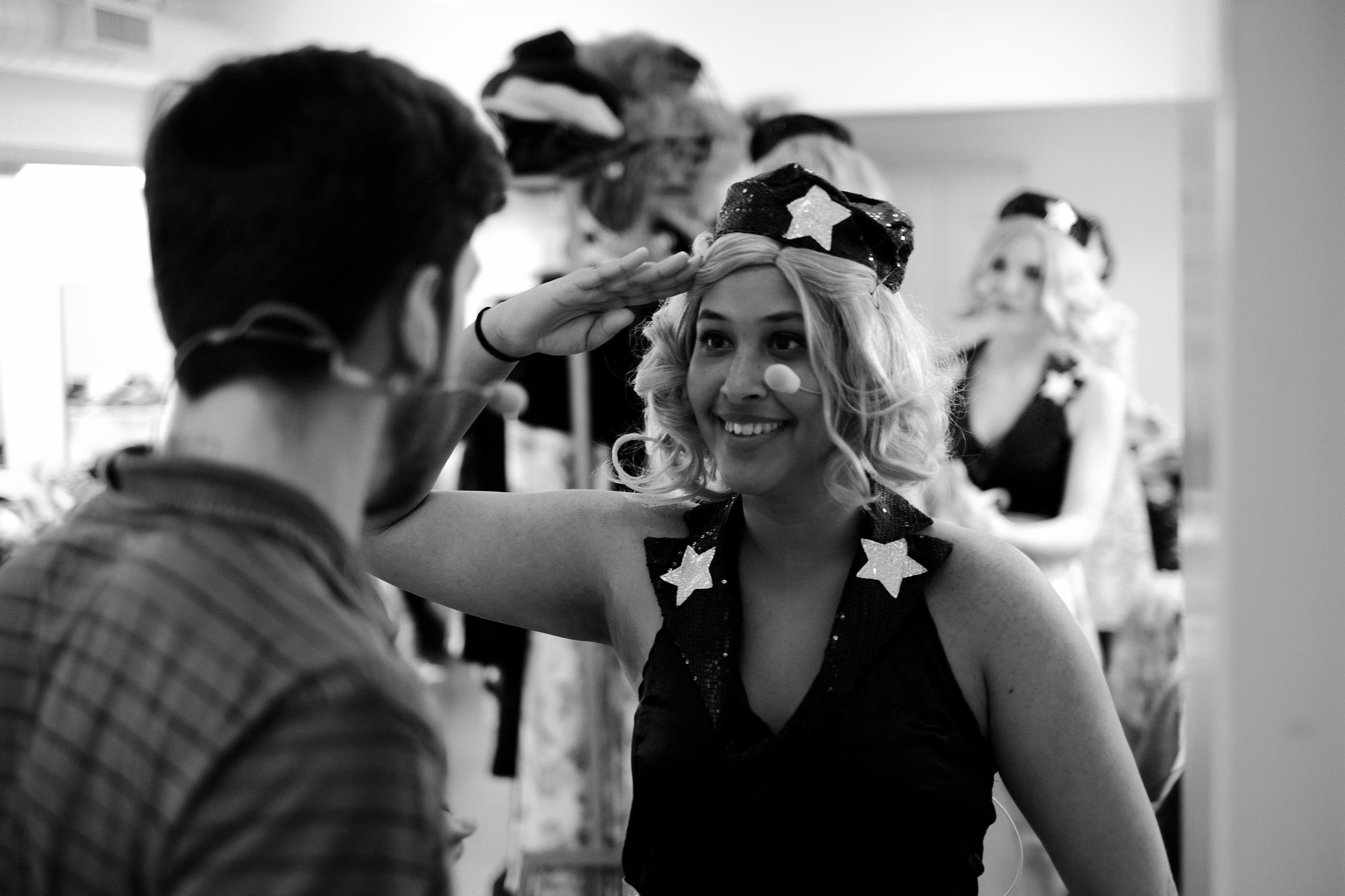 Ein Darstellerin lächelt hinter der Bühne in Kostüm in die Kamera.