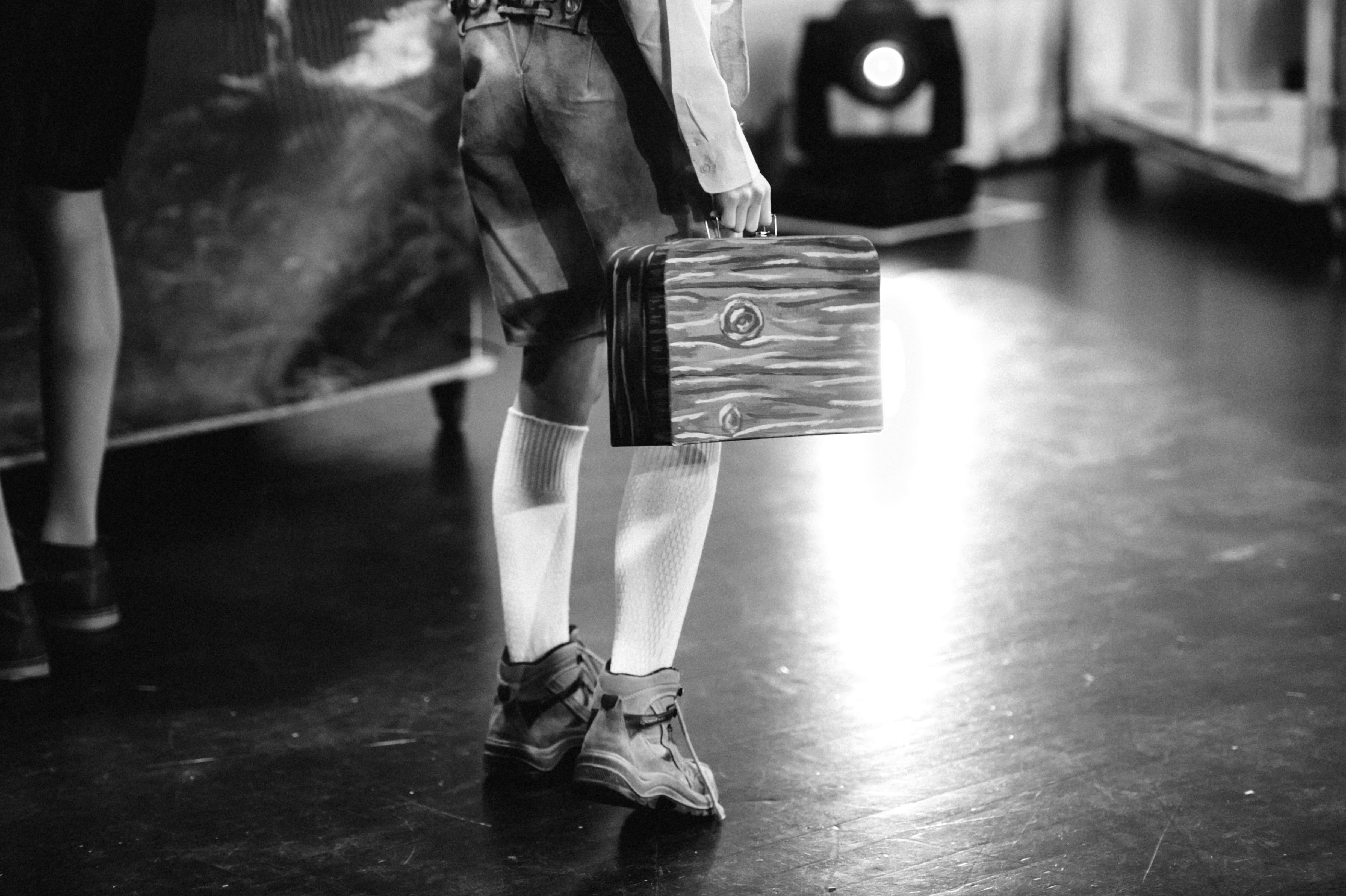 Ein Junge im Kostüm trägt einen kleinen Holzkoffer