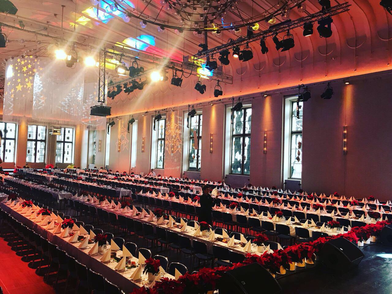 Großer Saal mit gedeckten langen Tischen