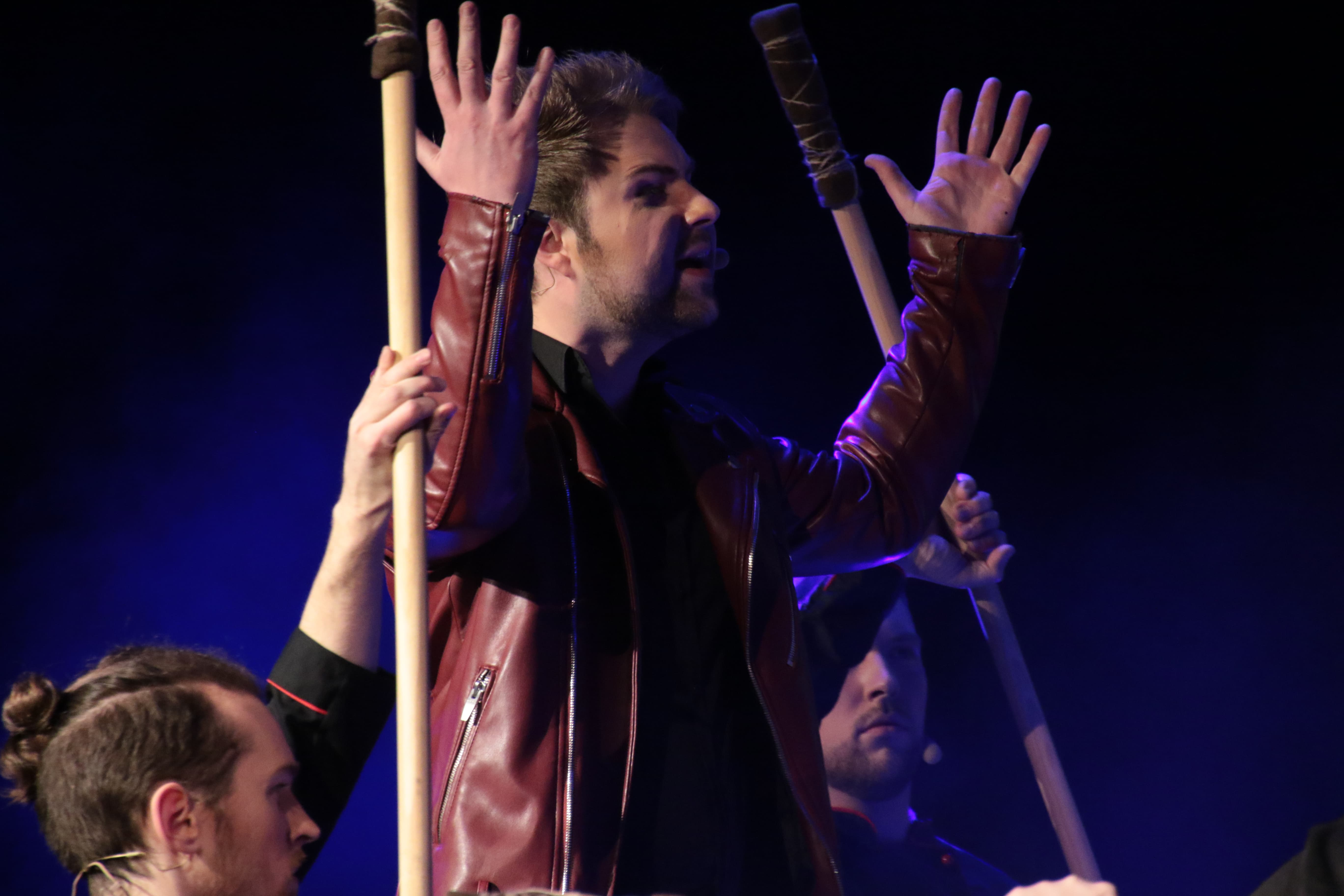 Sam Schlabs als Radames die Hände in die Luft geworfen. Zwei Wachen stehen mit Stöcken neben ihm.